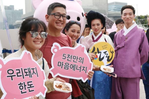 (사진)  서울 광화문광장에서 24일 열린 ‘2017 종로한복축제’에 참가한 외국인 관광객들이 한돈 캐릭터 ‘한도니’와 기념사진을 촬영하기 위해 포즈를 취하고 있다.